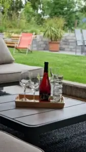 Flasche Dirndl Frizz mit Gläsern auf einem Tablett im Garten des Kräuterhäusl