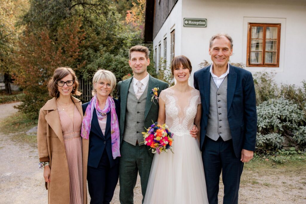 Brautpaar mit Familie vor dem Kräuterhäusl in Puchenstuben